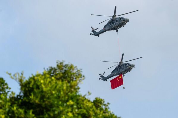 مروحيات صينية تحمل العلم الوطني الصيني خلال الاحتفال باليوم الوطني السادس والسبعين لجمهورية الصين الشعبية. - سبوتنيك عربي