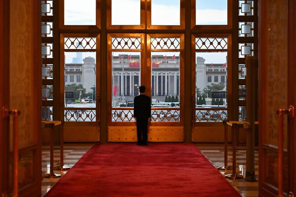 حارس أمن يقف أمام باب قاعة الشعب الكبرى، عشية اليوم الوطني لإحياء ذكرى تأسيس جمهورية الصين الشعبية. - سبوتنيك عربي