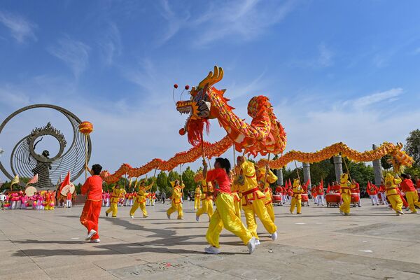 فنانون شعبيون يؤدون رقصة التنين في ساحة حديقة دونغيي للرموز الثقافية بمدينة تشينغتشو، الصين. - سبوتنيك عربي