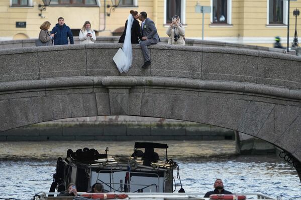 عريس وعروس يلتقطان صورة على جسر في مدينة سانت بطرسبورغ، روسيا - سبوتنيك عربي