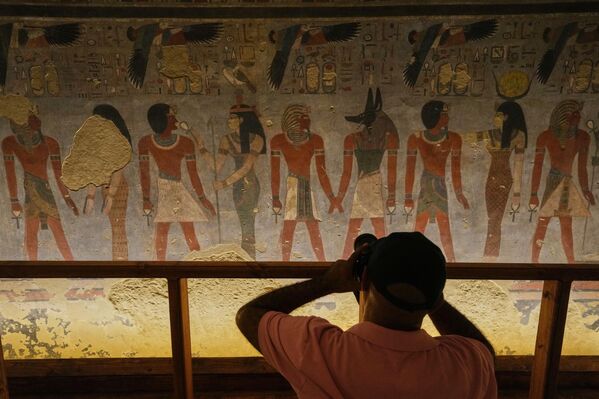 سائح يلتقط صور للرسومات على جدران مقبرة أمنحتب الثالث.  - سبوتنيك عربي