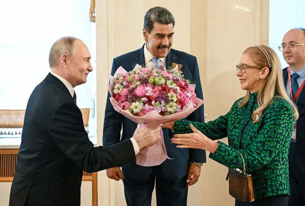 الرئيس الروسي فلاديمير بوتين، يقدّم باقة من الزهور لزوجة الرئيس الفنزويلي، سيليا فلوريس، خلال زيارة الرئيس الفنزويلي نيكولاس مادورو، وزوجته إلى الكرملين لحضور حفل موسيقي احتفالي لرؤساء الوفود الأجنبية المدعوين للاحتفال بالذكرى الثمانين للنصر في الحرب الوطنية العظمى. - سبوتنيك عربي