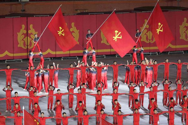 يحمل مشاركون في العروض الأعلام خلال تأدية إحدى العروض الفنية خلال الاحتفالات. - سبوتنيك عربي