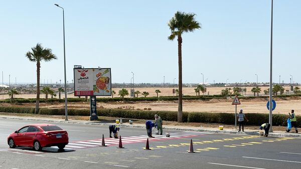 عمال يرسمون خط مرور في مدينة شرم الشيخ حيث يعقد الرئيس دونالد ترامب قمة لزعماء العالم بشأن غزة خلال زيارته - سبوتنيك عربي