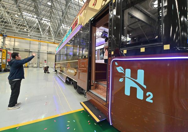 رجل يلتقط صورة لأول قطار سياحي يعمل بالهيدروجين في مقاطعة جيلين الصينية - سبوتنيك عربي