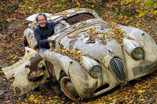 جامع السيارات مايكل فروليش أمام سيارة &quot;جاكوار&quot; كلاسيكية في الحديقة الخاصة في ميتمان، ألمانيا. - سبوتنيك عربي