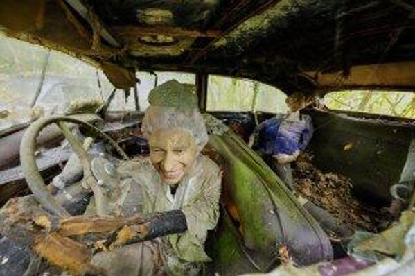 دمى الملكة إليزابيث الثانية وابنها تشارلز في سيارة رولز رويس قديمة في موقف سيارات قديم خاص في ميتمان، ألمانيا. - سبوتنيك عربي