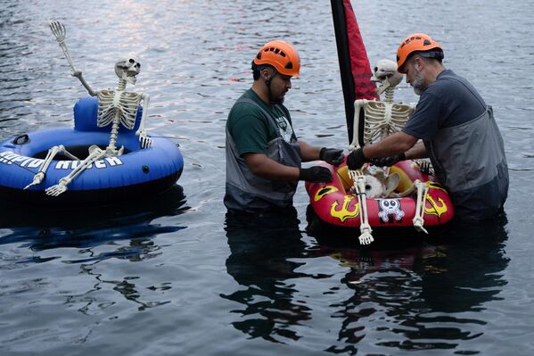 خوان أريدوندو، على اليسار، وكيلسي باركر، يعملان على تثبيت تمثال هيكل عظمي على أنبوب داخلي قبل سباق اليقطين العملاق على الساحل الغربي لولاية أوريغون الأمريكية، يوم الأحد، 19 أكتوبر/تشرين الأول 2025. - سبوتنيك عربي