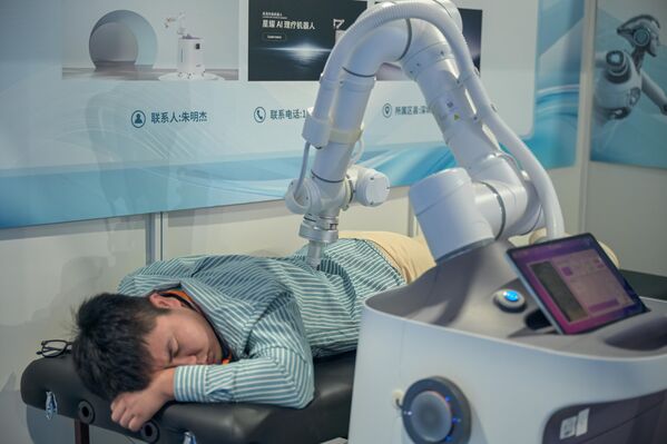 زائر يختبر روبوت تدليك خلال قمة هانغتشو لصناعة الروبوتات البشرية في 15 أكتوبر 2025 في هانغتشو، مقاطعة تشجيانغ الصينية. - سبوتنيك عربي