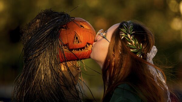 Девушка позирует подруге, целуя тыкву на Вестсайдском фестивале Hallo Fes в Бухаресте, Румыния - سبوتنيك عربي