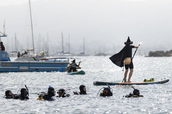  غواصون يشاهدون متزلجًا على الماء يرتدي زيًا تنكريًا خلال مسابقة السحرة والسحرة السنوية في خليج مورو، كاليفورنيا. - سبوتنيك عربي