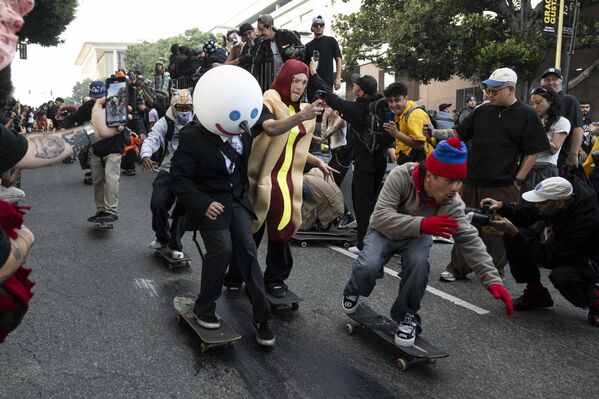  أشخاص يتزلجون على المنحدرات خلال فعالية "قنبلة الهالوين" للتزلج على الألواح، في لوس أنجلوس. - سبوتنيك عربي