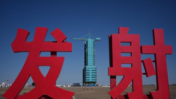 مركبة الفضاء شنتشو 21 جالسة على قمة صاروخ لونغ مارش مغطى بمنصة إطلاق بالقرب من الأحرف الصينية للإطلاق، في مركز جيوكوان لإطلاق الأقمار الصناعية في شمال غرب الصين، 30 أكتوبر/ تشرين الأول 2025 - سبوتنيك عربي