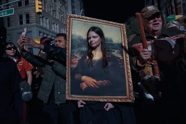 أحد المشاركين في احتفالات "الهالوين" يتوقف لالتقاط صورة خلال موكب "الهالوين" في نيويورك.  - سبوتنيك عربي