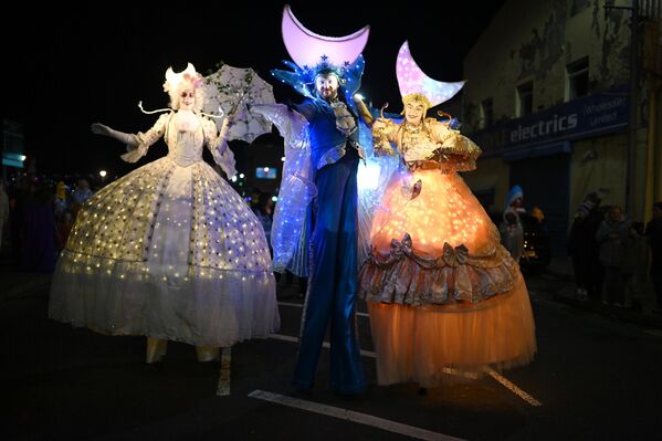  فنانون يرتدون ثيابًا كلاسيكية مضيئة أثناء مشاركتهم في موكب احتفالات "الهالوين" في أيرلندا الشمالية.  - سبوتنيك عربي