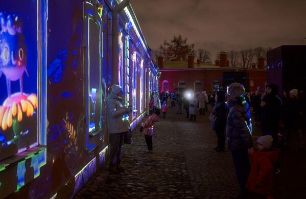 زوار يلتقطون صورا في مهرجان الفن الضوئي الرقمي &quot;فنون الضوء 2025&quot;، في قلعة &quot;بطرس وبولس&quot;، بمدينة سانت بطرسبورغ الروسية - سبوتنيك عربي