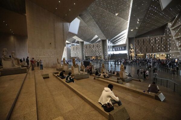  يستريح الزوار أثناء زيارتهم للمتحف المصري الكبير الذي يضم عشرات الآلاف من القطع الأثرية، بما في ذلك مجموعة الكنوز الكاملة التي اكتُشفت مع توت عنخ آمون، والبالغ عددها 5000 قطعة. - سبوتنيك عربي