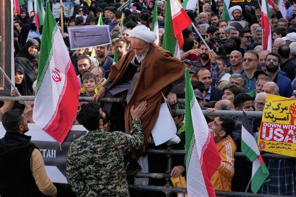 رجل يحاول عبور الحواجز خلال تجمع سنوي أمام السفارة الأمريكية السابقة في طهران، احتفالاً بذكرى الاستيلاء على السفارة عام 1979. - سبوتنيك عربي