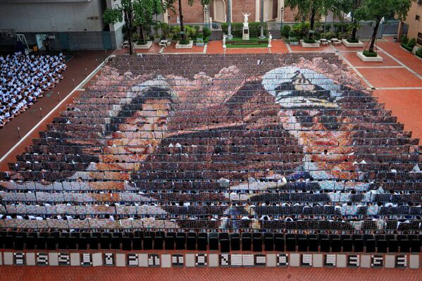 تشكيل فني دقيق على أرض الملعب الرياضي من قبل الطلاب في  بانكوك-تايلاند، هذا العرض المتزامن هو تعبير عميق عن الحزن والحداد على كل من الملك الراحل بوميبول أدولياديج والملكة الراحلة سيريكيت الملكة الأم. - سبوتنيك عربي