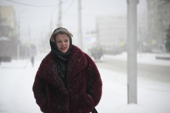شابة في شارع كراسني بروسبكت في نوفوسيبيرسك التي انخفضت فيها درجة الحرارة دون الصفر.  - سبوتنيك عربي