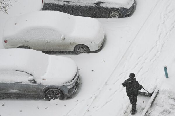 عامل يقوم بإزالة الثلوج من فناء منزل في نوفوسيبيرسك. - سبوتنيك عربي