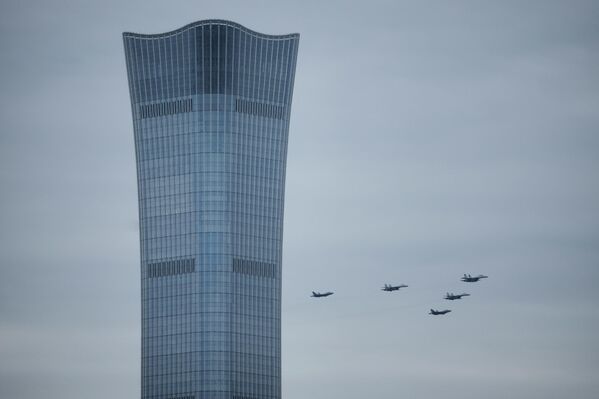 طائرات مقاتلة صينية من طراز&quot; J-16 &quot; وطائرات مقاتلة شبح من طراز &quot;J-35A&quot; تحلق فوق برج تشاينا زون، أطول ناطحة سحاب في العاصمة بكين، خلال &quot;بروفة&quot; العرض العسكري. - سبوتنيك عربي