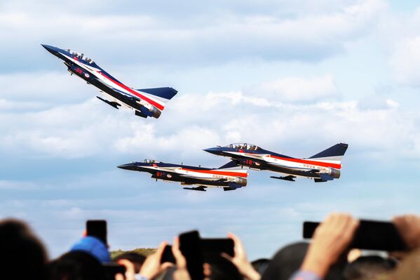  أشخاص يلتقطون صورًا خلال بروفة طيران استعدادًا لعرض تشانغتشون الجوي لعام 2025 في تشانغتشون. - سبوتنيك عربي