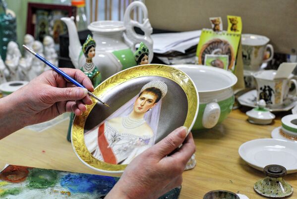 صورة تظهرعملية رسم وجه لفتاة، في فستان الزفاف على صحن خزفي. - سبوتنيك عربي