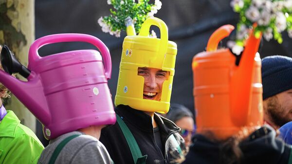 Участники карнавала в костюмах несут лейки на головах в Кельне, Германия - سبوتنيك عربي