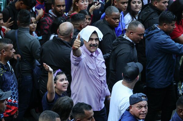  الرئيس الفنزويلي نيكولاس مادورو، يُحيي أنصاره خلال تجمع شبابي مؤيد للحكومة في العاصمة كاراكاس - سبوتنيك عربي