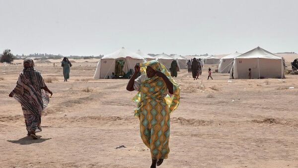 نساء سودانيات نازحات من الفاشر، عاصمة شمال دارفور، ومناطق أخرى متأثرة بالصراع، يسيرن في مخيم العفاد الذي تم إنشاؤه حديثا في الدبة، ولاية شمال السودان، 13 نوفمبر/ تشرين الثاني 2025 - سبوتنيك عربي