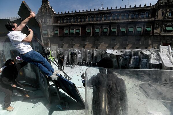 متظاهرون ينتزعون الأسوار المعدنية للقصر الوطني، خلال احتجاجات ضد الحكومة في المكسيك - سبوتنيك عربي