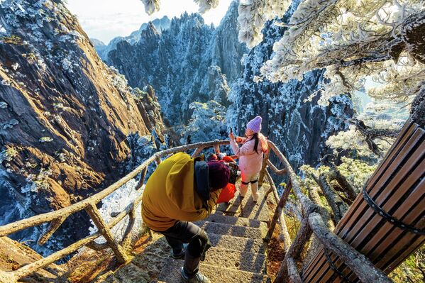 متسلقون يلتقطون صورًا لأشجار جبل "هوانغشان" الصينية المغطاة بالصقيع، مطلع الشتاء - سبوتنيك عربي