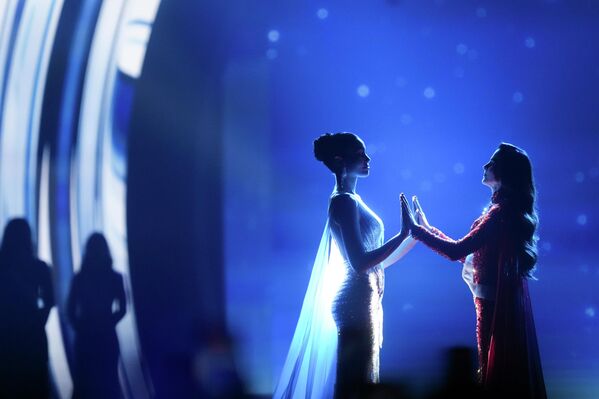 ملكة جمال المكسيك فاطمة بوش، وملكة جمال تايلاند برافينار سينغ، تمسكان أيدي بعضهما بعضا أثناء انتظار الإعلان عن اسم الفائزة بمسابقة ملكة جمال الكون لعام 2025، في تايلاند - سبوتنيك عربي