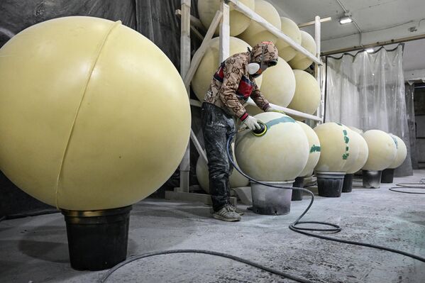 خلال قيام أحد العمال بتجهيز زينة شجرة عيد الميلاد التي ستنصب في ساحة تفرسكايا في موسكو.  - سبوتنيك عربي