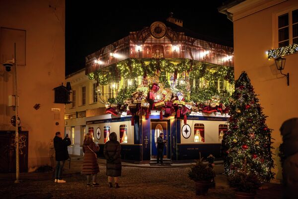 صورة توثق تجمهر الناس حول زينة عيد الميلاد في البلدة القديمة في فيلنيوس، ليتوانيا.  - سبوتنيك عربي