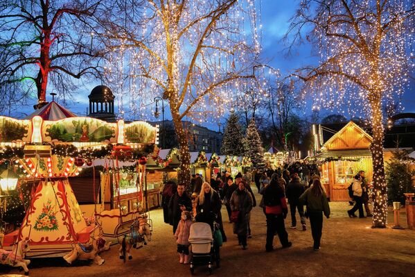 عدد من الأشخاص يستمتعون بوقتهم في سوق عيد الميلاد في العاصمة الألمانية برلين. - سبوتنيك عربي