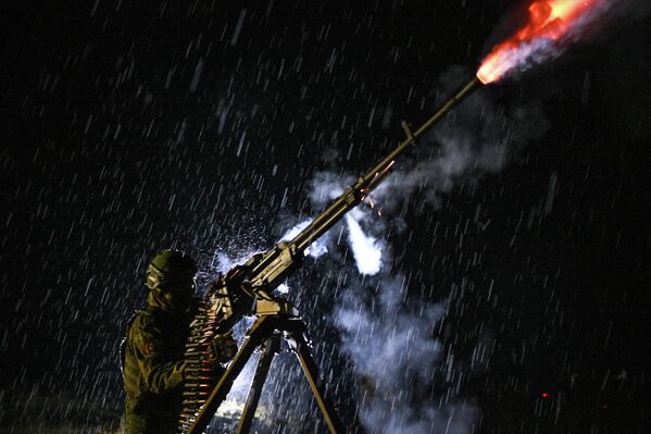 صورة تظهر جنديا روسيًا يقف تحت المطر ويقوم بإطلاق النيران من سلاحه - سبوتنيك عربي