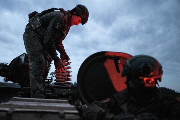 صورة تظهر جنديان روسيان في عربة عسكرية أحدهم ينظر إلى الأمام، والآخر يقوم بتجهيز الذخيرة - سبوتنيك عربي