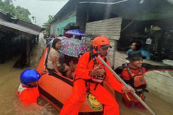 في هذه الصورة الصادرة عن الوكالة الوطنية الإندونيسية للبحث والإنقاذ (باسارناس)، يقوم رجال الإنقاذ على متن قارب مطاطي، بإجلاء السكان من منازلهم التي غمرتها الفيضانات في مقاطعة سومطرة الشمالية بإندونيسيا - سبوتنيك عربي