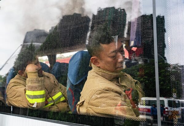 استراحة رجال الإطفاء خلال تبديل نوبتهم في مجمع "فان فوك كورت" السكني في هونغ كونغ - سبوتنيك عربي