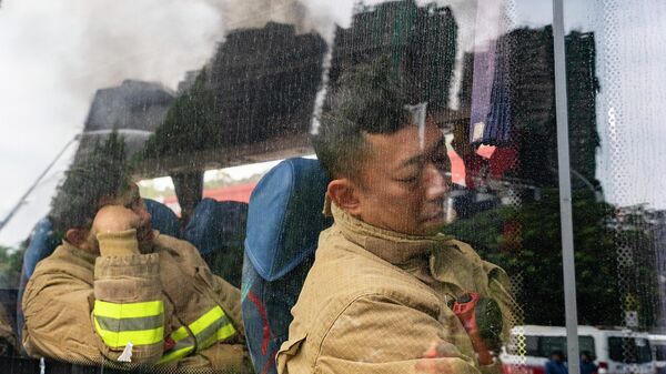 Пожарные отдыхают во время пересменки у жилого комплекса Ван Фук Корт в Гонконге - سبوتنيك عربي