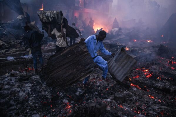  رجال الإطفاء يسيطرون على حريق اندلع في نيروبي في كينيا، بينما يحاول السكان إنقاذ ما تبقى من ممتلكاتهم. - سبوتنيك عربي