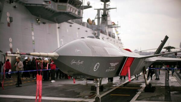أشخاص يقفون بجوار الطائرة بدون طيار القتالية من طراز بيرقدار قزل إلما على متن السفينة الهجومية البرمائية التركية TCG Anadolu L400، الراسية في إسطنبول، تركيا، 20 نيسان/ أبريل 2023 - سبوتنيك عربي