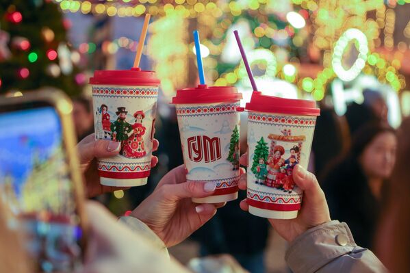 أحد الزورار يلتقط صورة لأكواب المشروبات الساخنة التي تزينت برسومات من وحي فعالية التزلج. - سبوتنيك عربي