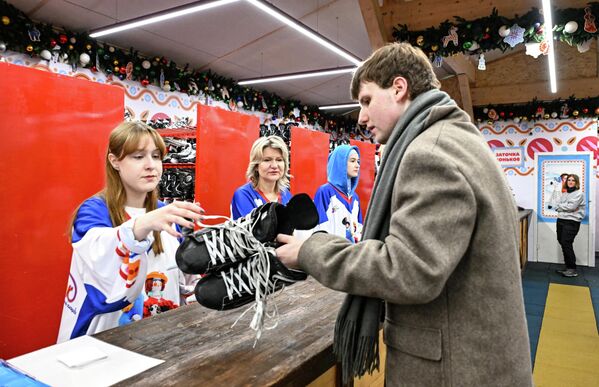 خلا قيام أحد الزوار بتسليم حذائه واستلام الحذاء الخاص بالتزلج. - سبوتنيك عربي