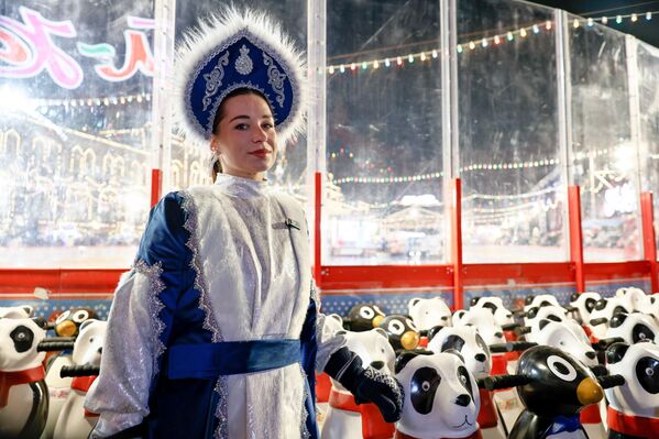 فتاة ترتدي زيًا تقليديًا، تلتقط صورة تذكارية وسط مجموعة من ألعاب التزلج.  - سبوتنيك عربي