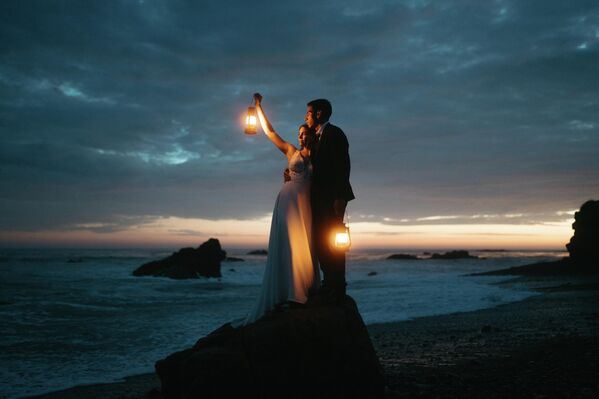 سامي ومايكا تشافين، الفائز في الولايات المتحدة الأمريكية، عن صورة تظهر عروسين يقفان على شاطئ البحر ويحملان بأيديهما مصابيح. سامي ومايكا تشافين، الفائز في الولايات المتحدة الأمريكية، عن صورة تظهر عروسين يقفان على شاطئ البحر ويحملان بأيديهما مصابيح. - سبوتنيك عربي