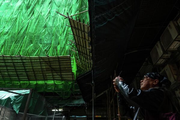 أشخاص يلتقطون صورا لمبنى قيد التجديد في منطقة خليج المحجر، بعد الحريق المميت في محكمة &quot;وانج فوك&quot;، في منطقة &quot;تاي بو&quot; في الأراضي الجديدة في هونغ كونغ. - سبوتنيك عربي