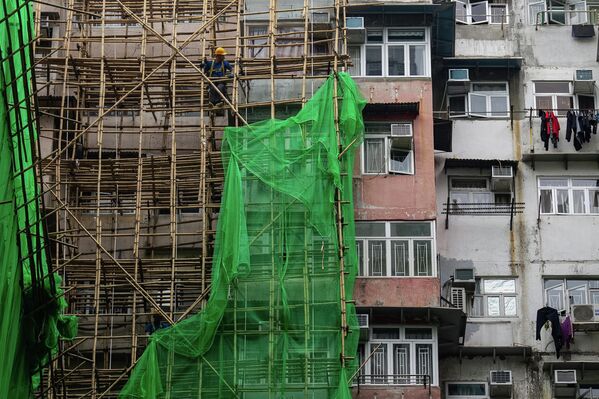 عمال البناء يقومون بإزالة شبكات &quot;السقالات&quot; من مشروع تجديد في منطقة خليج المحجر. - سبوتنيك عربي